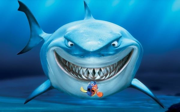 Кадр из мультфильма «Спасти Немо»: огромная зубастая акула за спиной двух крошечных испуганных рыбок.